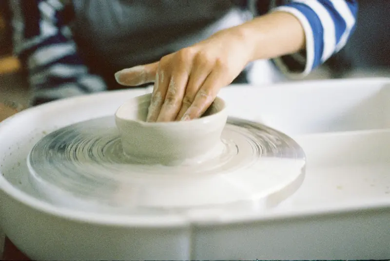 Close-up of hands shaping clay on a pottery wheel, showcasing the art of handmade ceramics