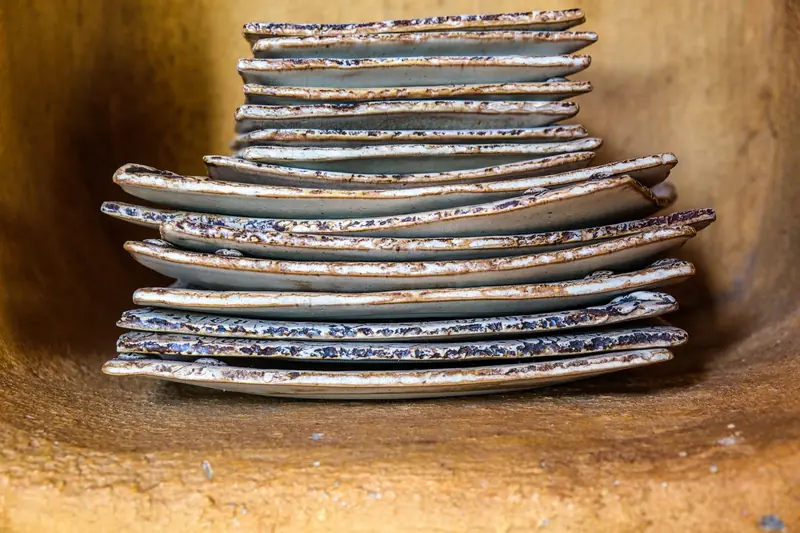 Close-up of a stack of vintage rustic ceramic plates with a textured finish