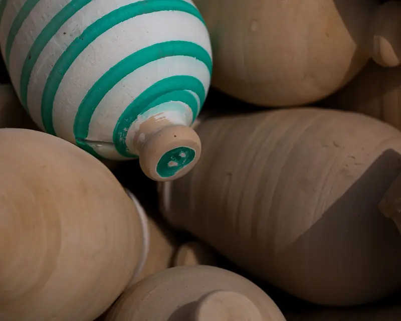 A detailed close-up of traditional clay pots featuring a striped design, highlighting craftsmanship
