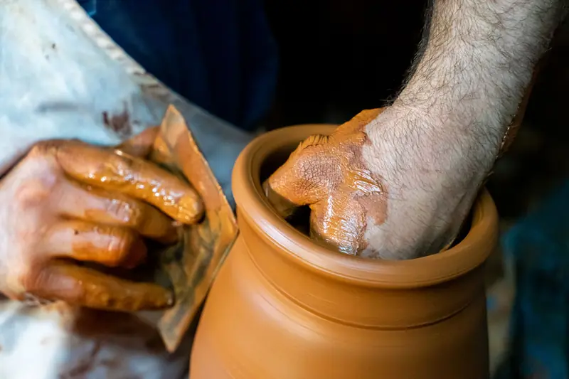 Artisan's hands shaping a clay pot on a pottery wheel, capturing craftsmanship and creativity
