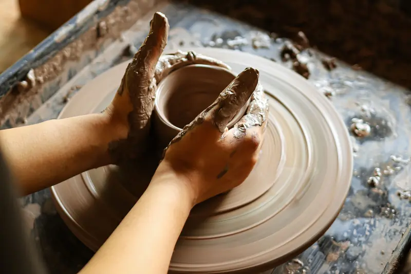 Close-up of hands crafting pottery on a wheel, showcasing skill and artistry